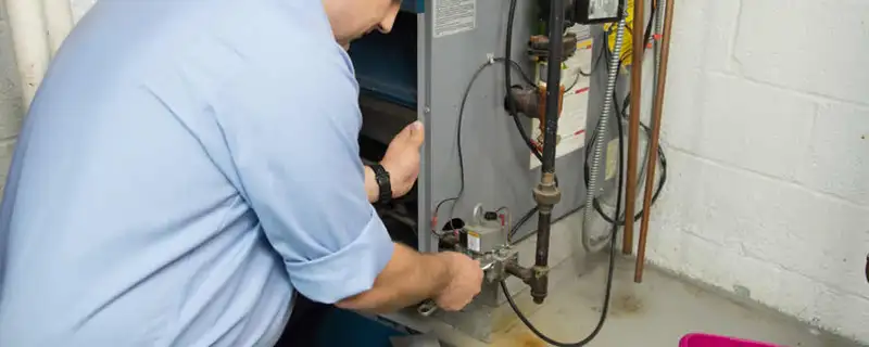 Furnace repair technician inspecting and servicing a home heating system in Glendale, AZ