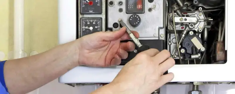 Heating repair technician adjusting boiler controls and components in Glendale, AZ