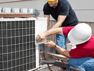 HVAC technicians repairing an outdoor AC unit on a rooftop in Glendale, AZ