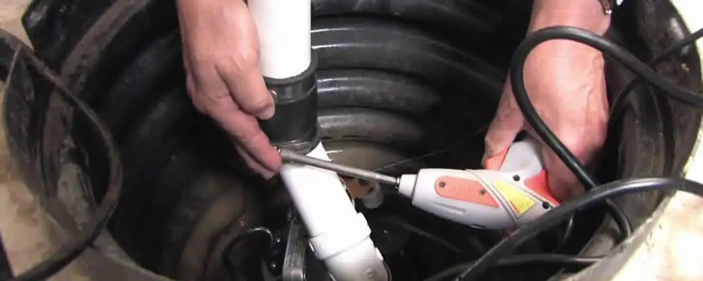Sump pump installation technician connecting PVC discharge piping in Glendale, AZ