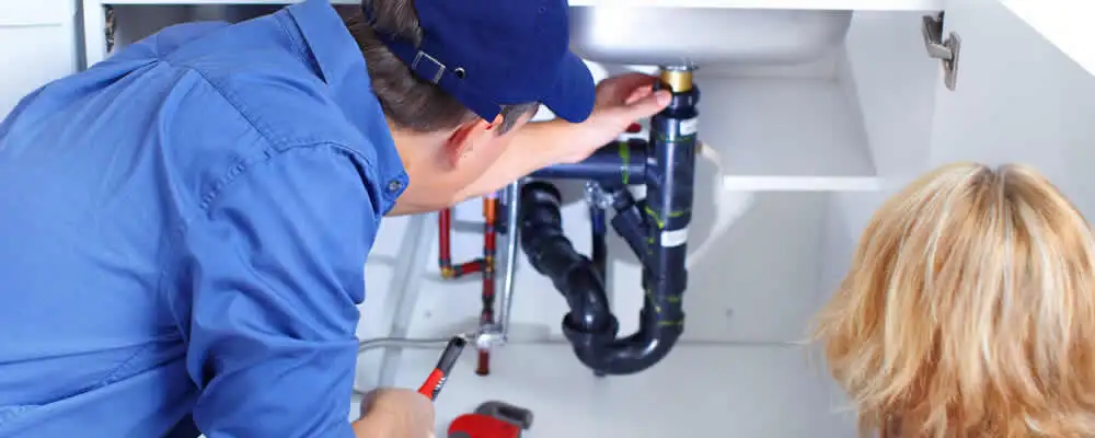 Plumber repairing under-sink drain pipes and fittings in Glendale, AZ